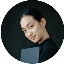 Portrait of a young Asian woman holding a laptop.