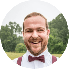 Portrait of a cheerful bearded man in a burgundy bow tie.
