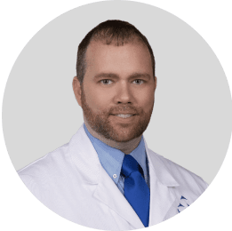 Portrait of a male dentist in a blue coat smiling