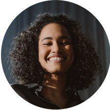 Portrait of a smiling young woman with curly hair.