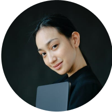 Portrait of a young Asian woman holding a laptop.