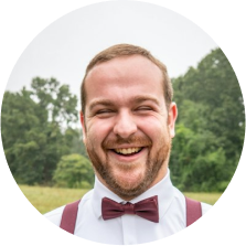 Portrait of a cheerful bearded man in a burgundy bow tie.